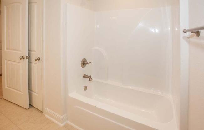 a white bath tub in a bathroom with a door