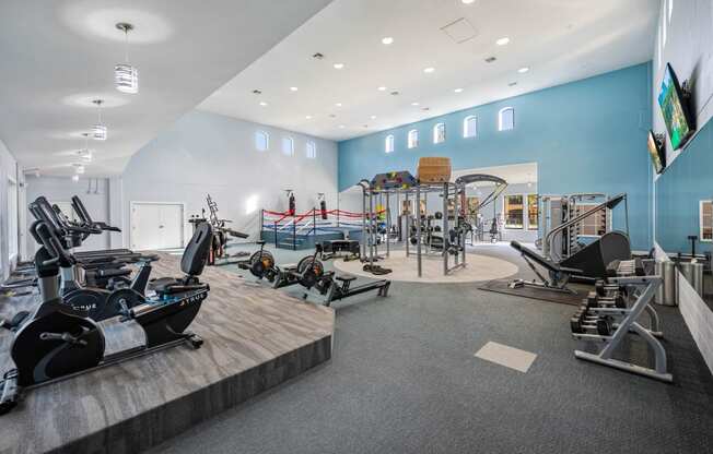 a gym with cardio equipment and weights on a wooden floor