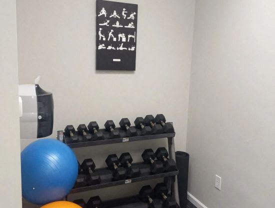 a room with a bunch of dumbbells and a wall with a workout room