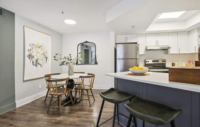 A kitchen with a dining table and chairs.