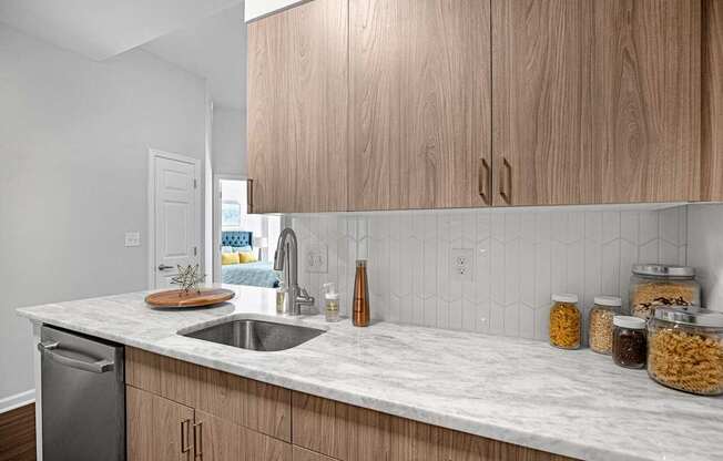 A kitchen with wooden cabinets and a marble countertop.