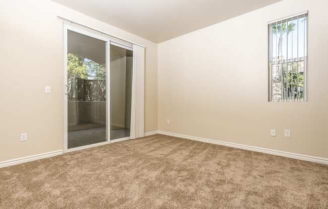 a bedroom with carpet and sliding glass door
