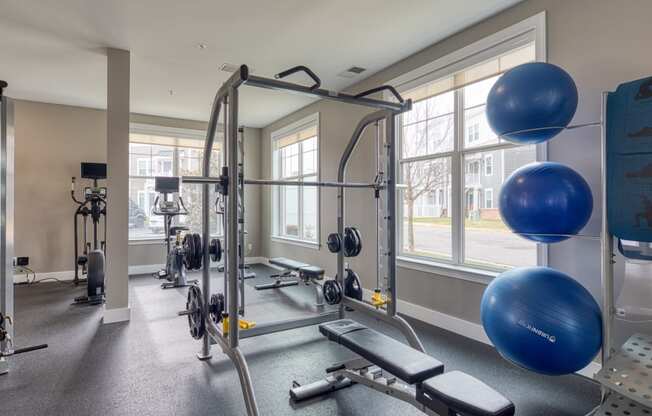 a gym with exercise equipment and windows at the enclave apartments