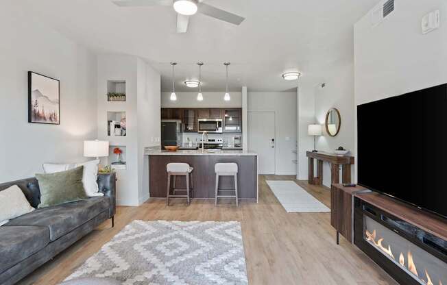 A modern living room with a grey couch and a fireplace.