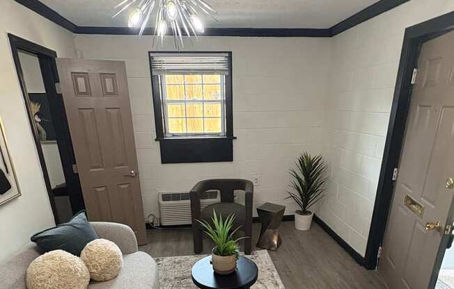 A living room with a grey couch and a wall with a black and white pattern.