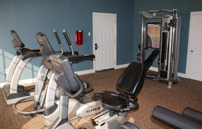 This is a photo of the fitness center showing workout machines at Woodbridge Apartments in Dallas, TX.