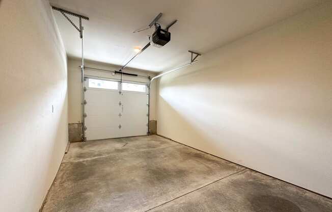 a garage with a white door and a ceiling fan