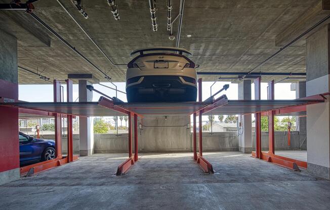 Parking area with an advanced lift system, controlled access, and charging stations for electric cars.