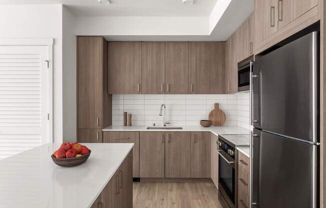 A modern kitchen with a bowl of apples on the counter.