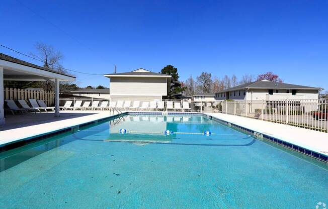 A large swimming pool with a building in the background.
