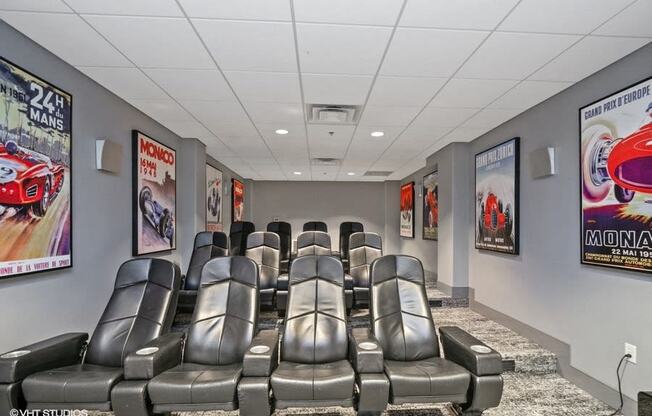 a theater room with leather chairs and movie posters on the walls