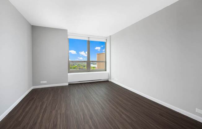 A room with a window overlooking a building.