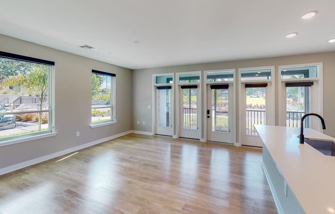 an empty living room with windows and doors