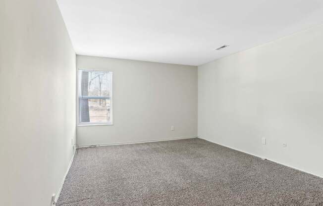 Empty room with carpeted floor and a window.