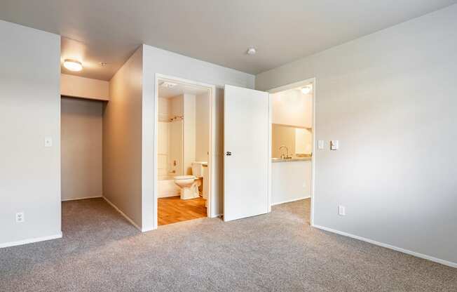 a bedroom with an open door to a bathroom
