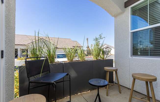 a small patio with two stools and two tables