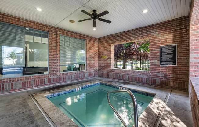 the indoor spa with brick walls and a ceiling fan at Eagles Landing Apartments, Ammon