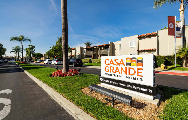 a sign grande apartment homes in front of a street