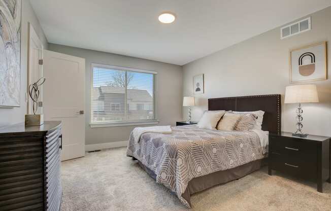 a bedroom with a bed and a dresser and a window