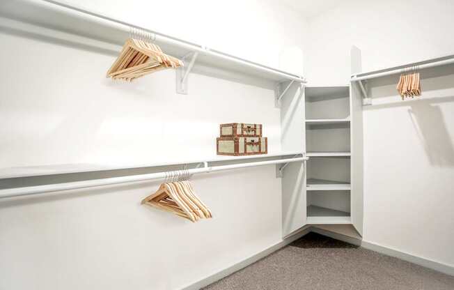 A white closet with shelves and hangers.