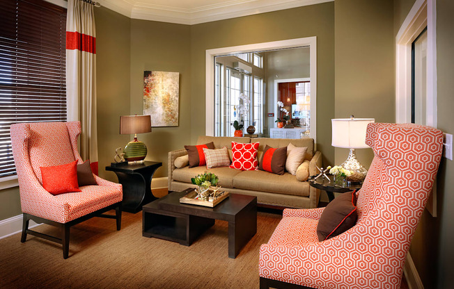 A living room with a red chair and a red and white patterned chair.