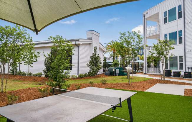 a ping pong table sits in the middle of a grassy area in front of a