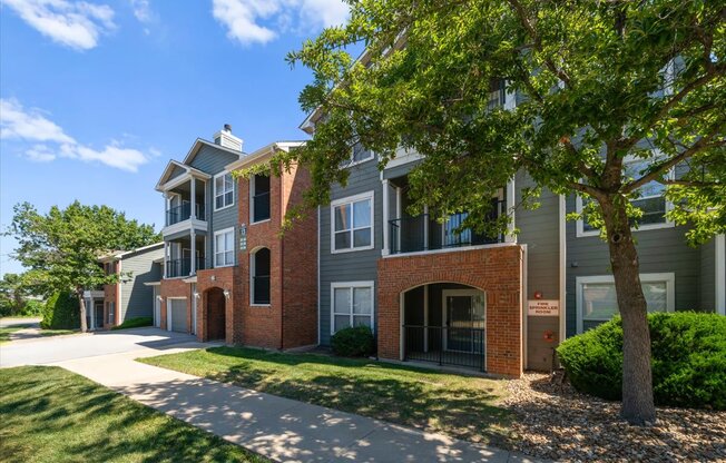 A tree is in front of a building. at Somerset Oaks Apartment Homes, Olathe