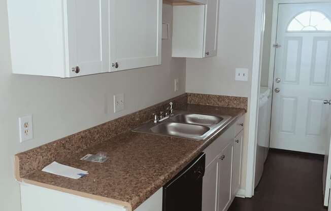 a kitchen with white cabinets and granite countertops