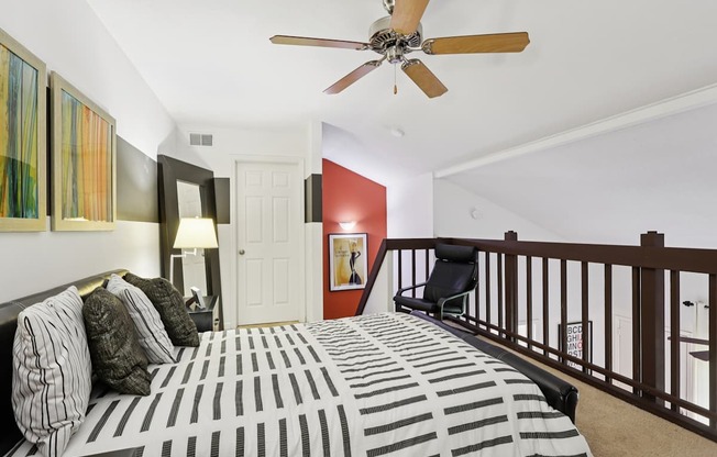A bedroom with a bed and a ceiling fan.