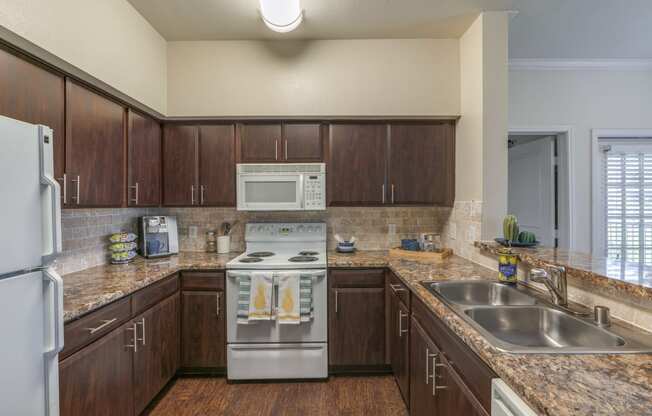 Two Bedroom Apartments in Spring TX - Edgewater at Klein - Spacious Kitchen with Wood-Style Cabinets and Marble Style Countertops