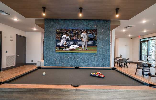 a game room with a pool table and a wall mural of a baseball game