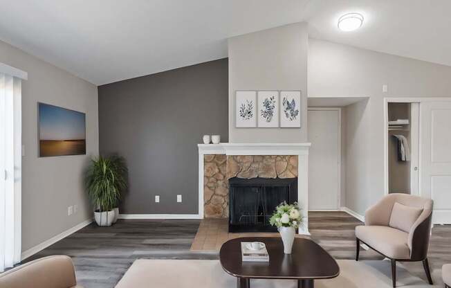 A living room with a fireplace and a painting on the wall.