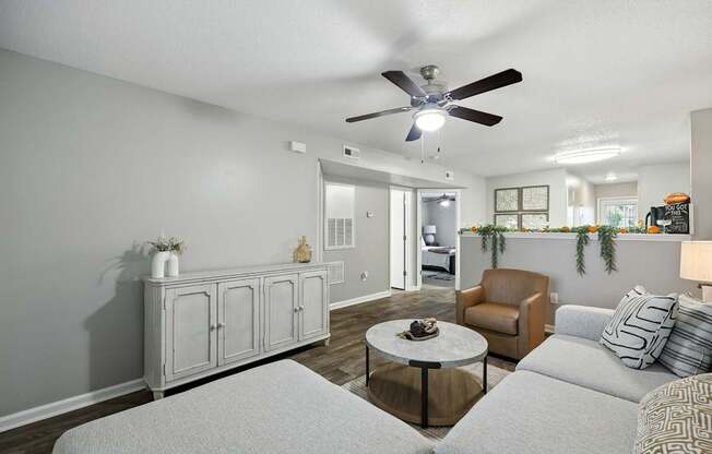 A living room with a white couch and a ceiling fan.