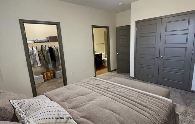 A bedroom with a bed, a wardrobe, and a mirror.