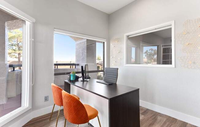 A kitchen with a black countertop and orange chairs.
