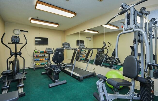 a gym with weights and other exercise equipment in a home gym at Huntington Terrace North Senior, Huntington Beach, CA 92648