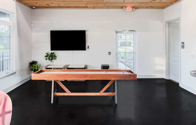 a room with a ping pong table and a tv on the wall