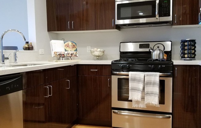 A modern kitchen with wooden cabinets and stainless steel appliances at Woodley Sara Apartment, California, 91406