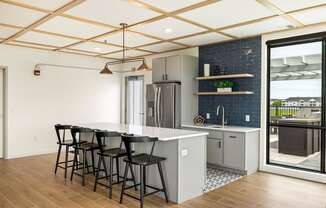 a kitchen with a white counter top and black bar stools at The Standard on 32nd, West Fargo