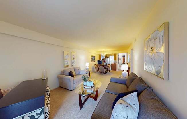 A living room with a couch, coffee table, and a painting on the wall.
