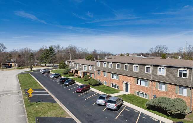 an aerial view of an apartment complex with cars parked in a parking lot