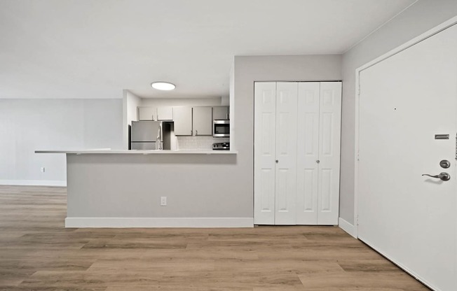A kitchen with white cabinets and a white door.