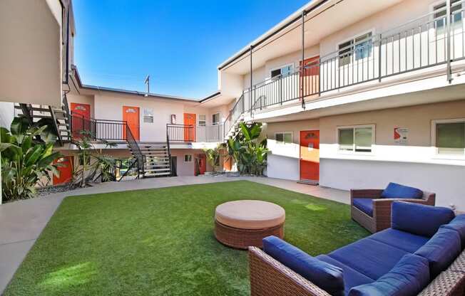 a yard with a couch and a table in front of some apartments