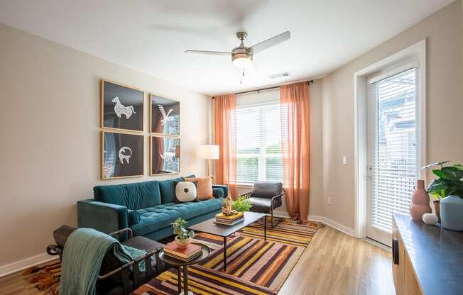 a living room with a blue couch and a ceiling fan