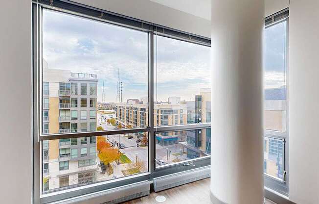 a floor to ceiling window with a view of midtown crossing from the living room of the 2-bedroom Tuscon