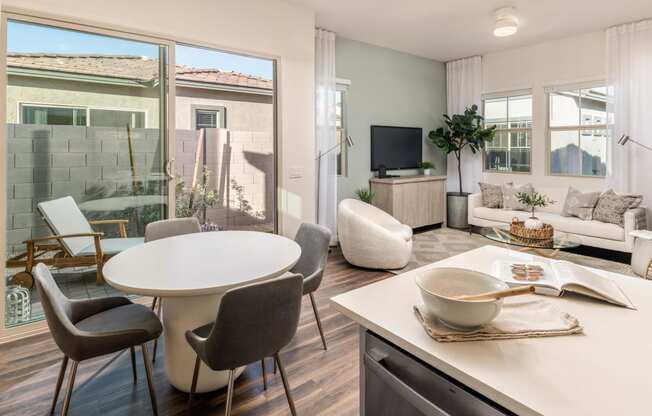 a living room and dining room with a table and a tv