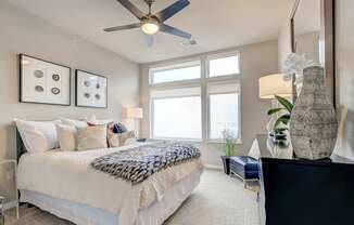 A bedroom with a large bed and a ceiling fan.