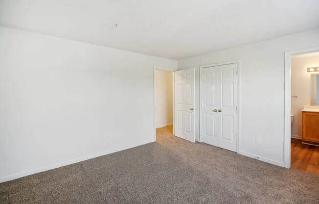 A room with white walls and a grey carpet.