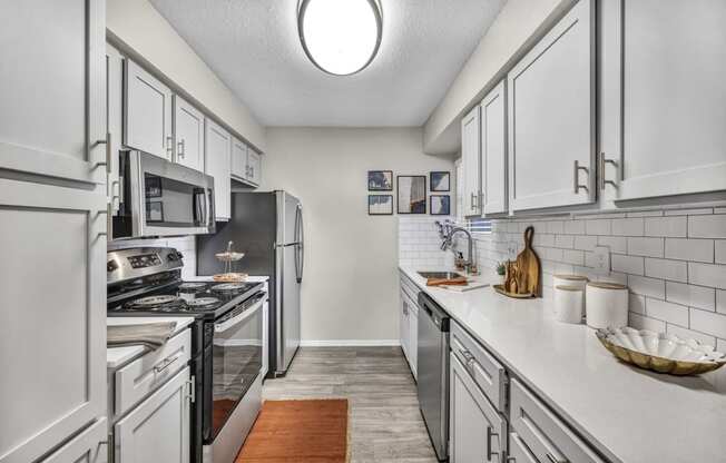a kitchen with white cabinets and stainless steel appliances