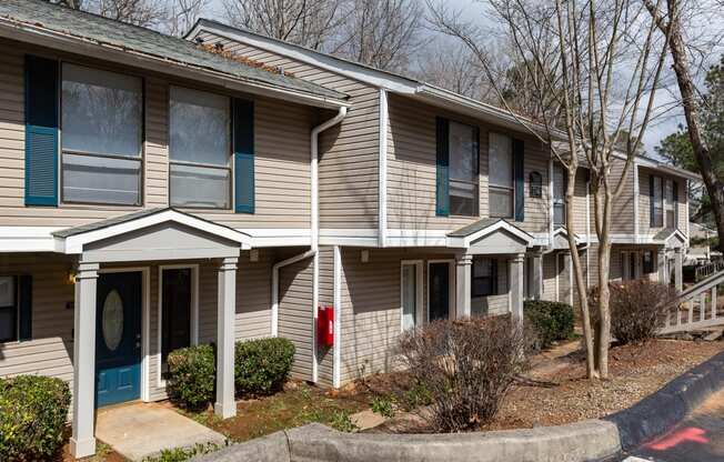 a tan house with blue trim and a red mailbox